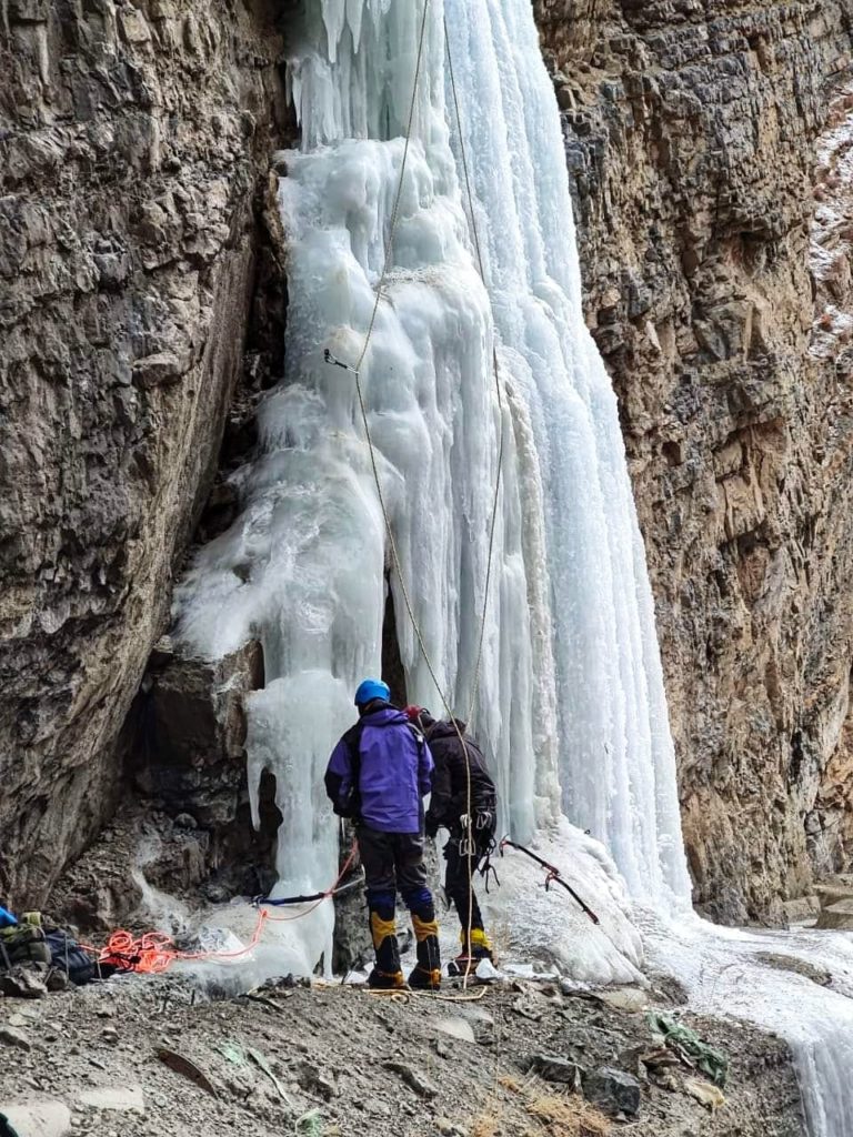 Preparing climbing equipment at base of frozen fall